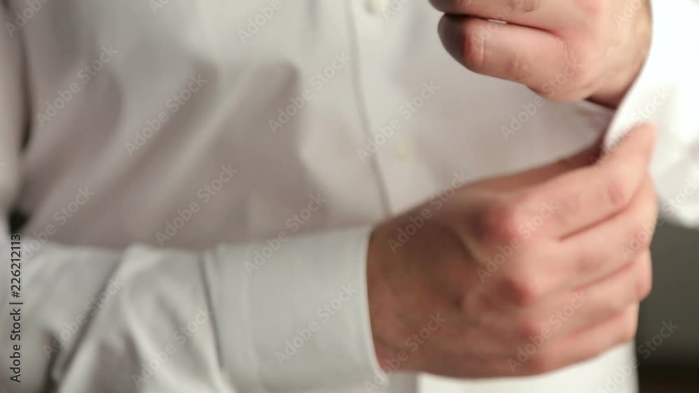 Businessman buttoning buttons on shirt sleeves, close-up. A successful man in a white shirt fastens buttons on the sleeves, close-up. Businessman buttoning buttons on shirt sleeves, close-up. A successful man in a white shirt fastens buttons on the sleeves, close-up.