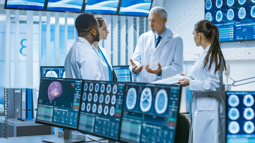 Meeting of the Team of Medical Scientists in the Brain Research Laboratory. Neurologists / Neuroscientists Having Heated Discussion Surrounded by Monitors Showing CT, MRI Scans.