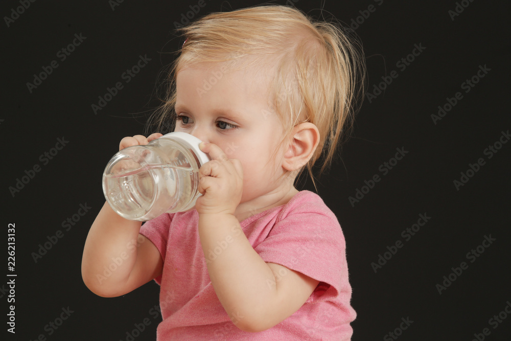 Portrait of a cute baby girl drinking water from a baby bottle Portrait of a cute baby girl drinking water from a baby bottle