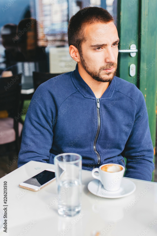 Young man sitting in a coffee bar Young man sitting in a coffee bar