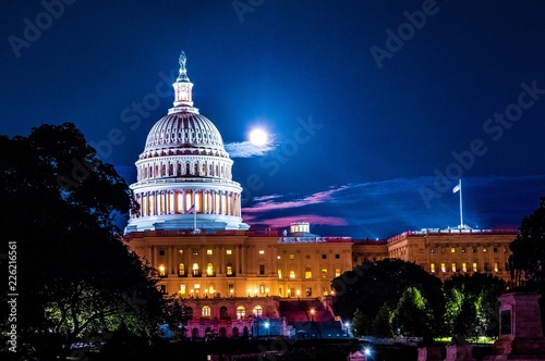 United Stated Capital dome illuminated at night with full moon in background