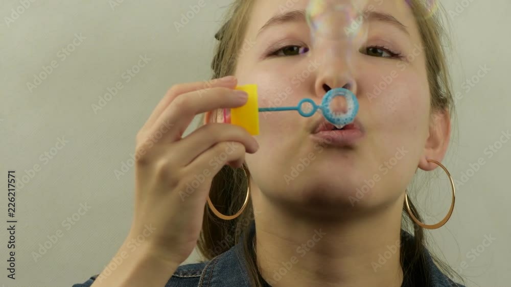 Asian young girl playing with a bubble blower. Asian young girl playing with a bubble blower.