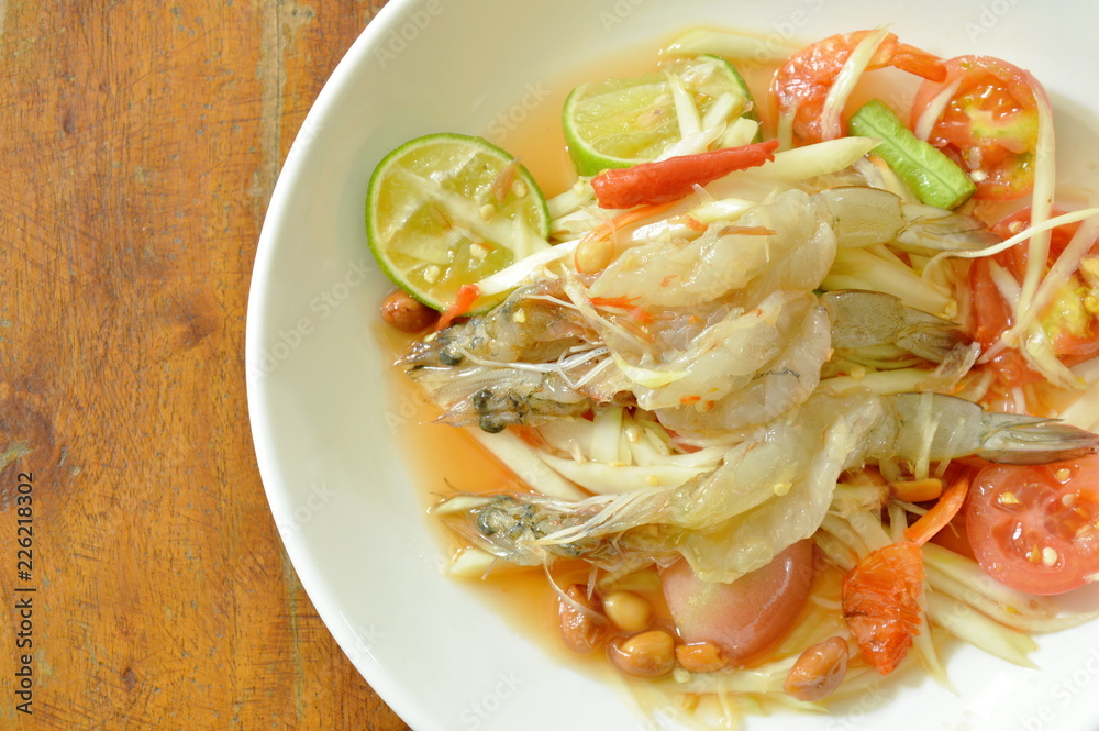 Som tum Thai spicy green papaya topping raw prawn salad on plate