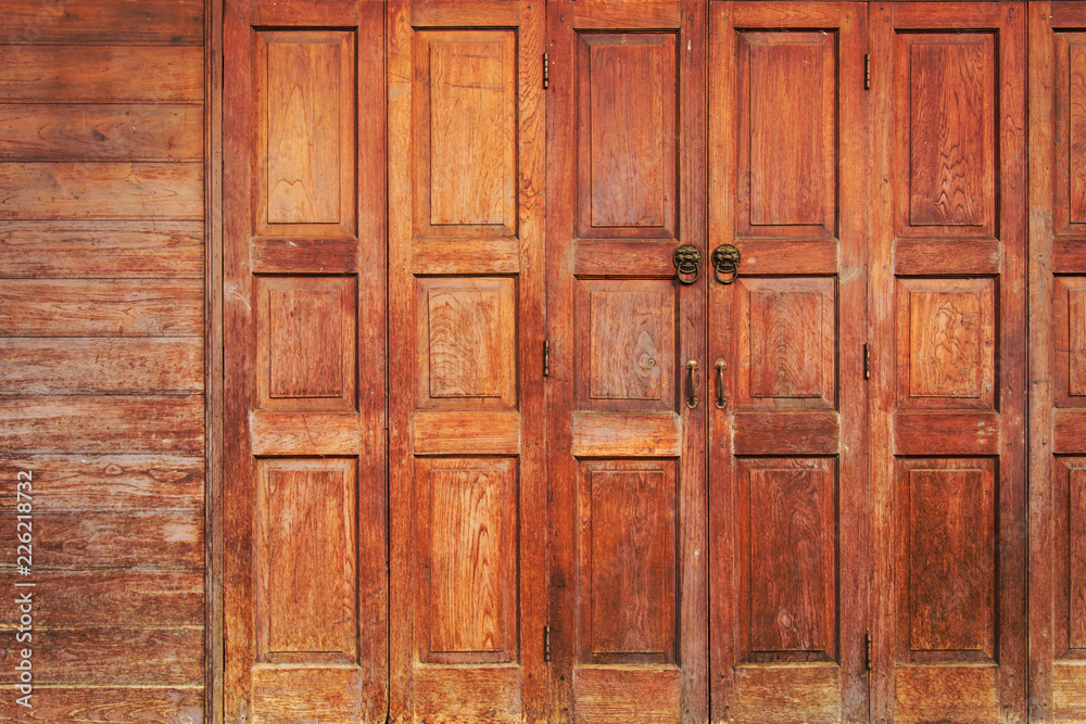 Old wooden folding doors with lion head door handle. Art background. Old wooden folding doors with lion head door handle. Art background.