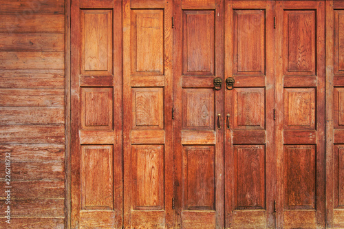 Fototapeta Naklejka Na Ścianę i Meble -  Old wooden folding doors with lion head door handle. Art background.
