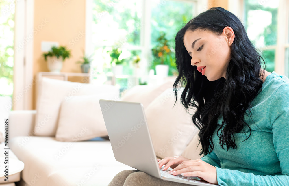 Young woman with a laptop computer in a bright interior room Young woman with a laptop computer in a bright interior room