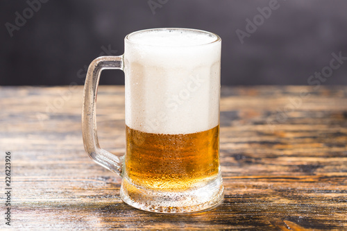 Glass of beer on wooden table. A mug of beer photo