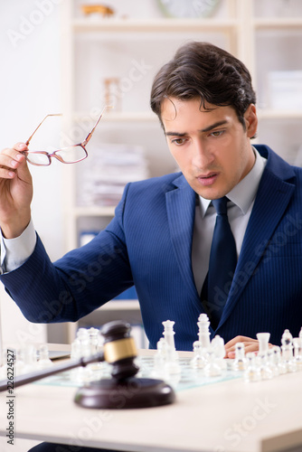 Young lawyer playing chess to train his court strategy and tacti photo