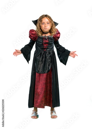 A full-length shot of a Kid dressed as a vampire at halloween holidays makes funny and crazy face emotion isolated on white