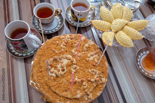 Hazelnut milk cake . Delicious cakes with hazelnut on wooden glass table . Black tea in glass cup on the table . Shekerbura with nuts and honey .Delicious dessert holiday food shekerbura