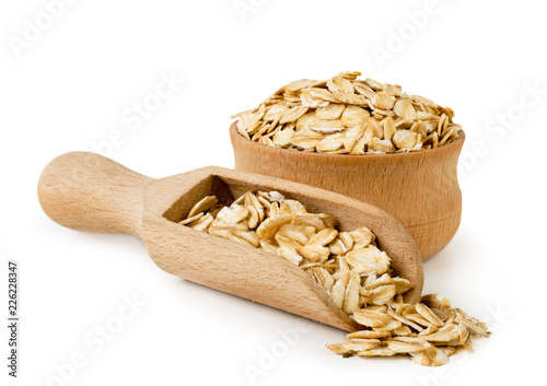 Oat flakes in wooden plate and spoon on a white background. Isolated.