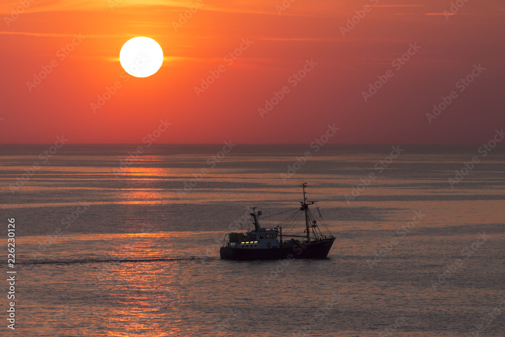 Fishing trawler on the North Sea at sunset