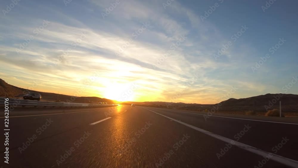 Driving into the sunset on Interstate 15 in the Mojave desert near Barstow, California. Driving into the sunset on Interstate 15 in the Mojave desert near Barstow, California.