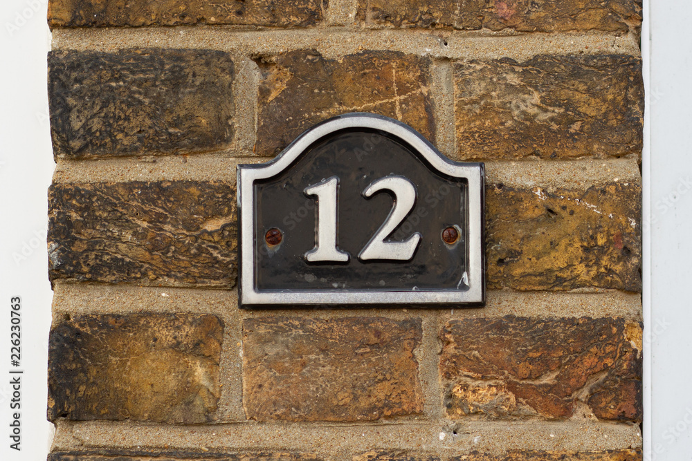 House Number 12 written in white on black enamel House Number 12 written in white on black enamel