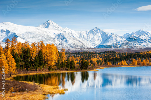 Kidelu lake, snow-covered mountains and autumn forest in Altai Republic, Siberia, Russia photo
