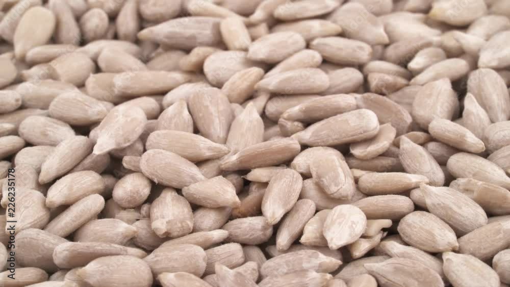 Full frame macro shooting of sunflower seed kernels heap. Rotating on the turntable, isolated on the white background. Close-up. Full frame macro shooting of sunflower seed kernels heap. Rotating on the turntable, isolated on the white background. Close-up.