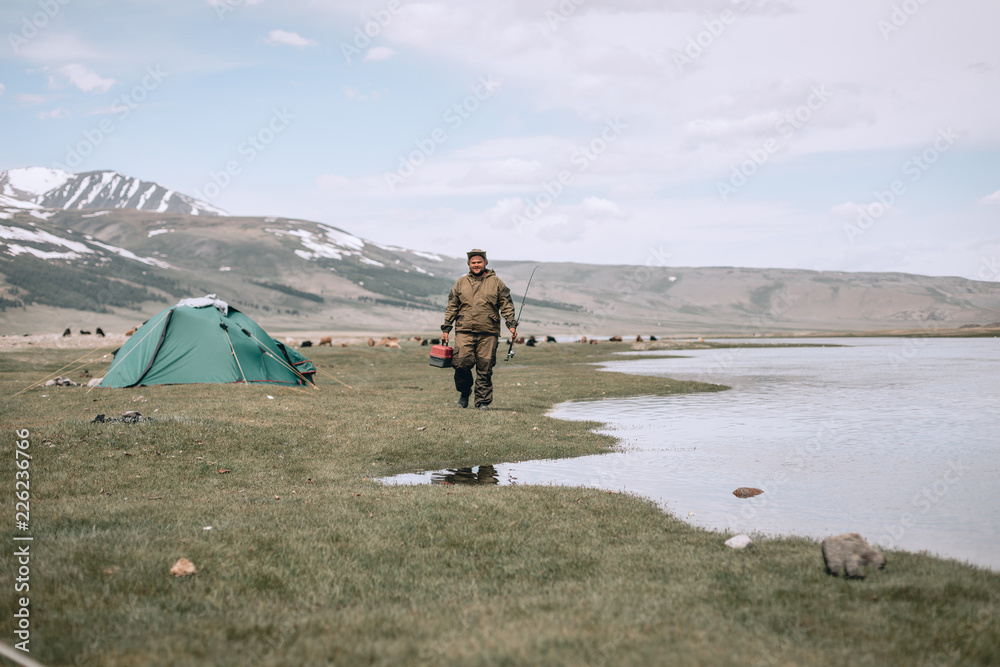 Fototapeta premium A fisherman selects the right Accessories that he is going to fish with. fishing tackles and fishing gear on in the hands