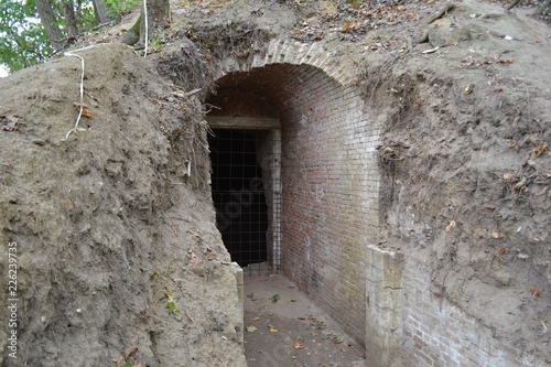 Fototapeta Naklejka Na Ścianę i Meble -  Excavated tunnel and gate in an earthen city fortification in Leuven, Belgium. The fortification does not have a door but is closed by means of metal bar grating.