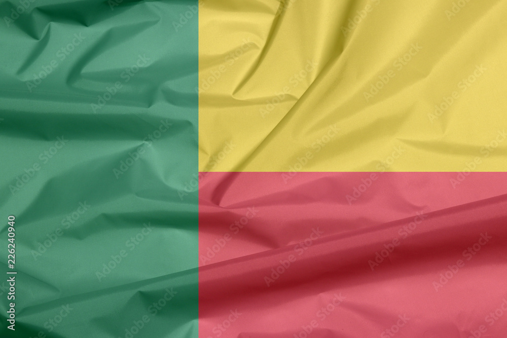 Obraz premium Fabric flag of Benin. Crease of Beninese flag background, A horizontal bicolor of yellow and red with a green vertical band.