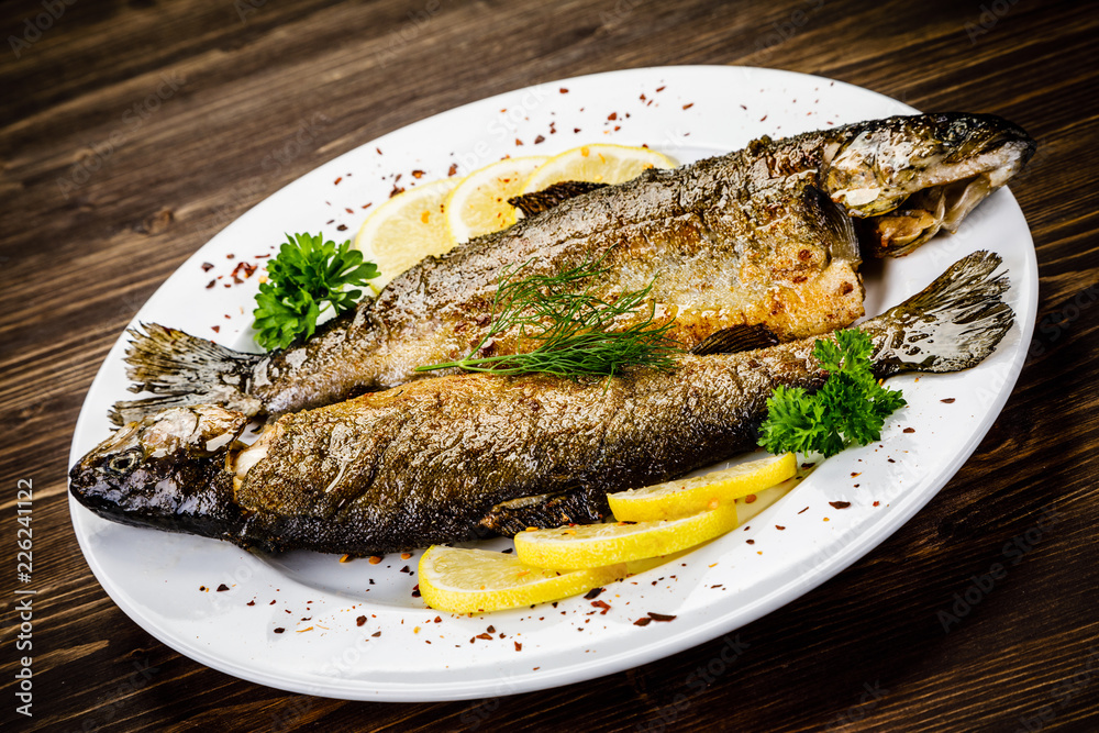 Fish dish - fried fish fillet on wooden table Fish dish - fried fish fillet on wooden table