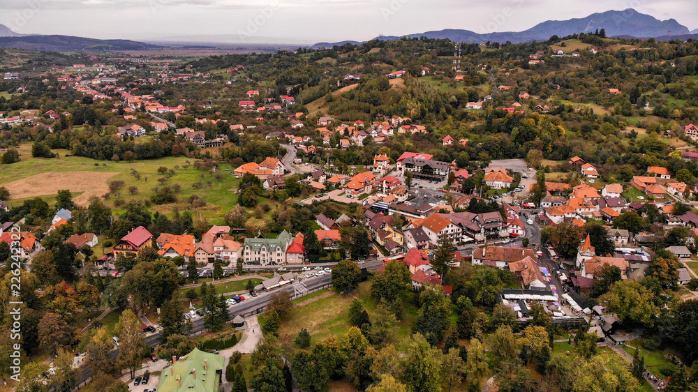 Aerial view of Bran town near the Bran castle in Transylvania, Romania, Brasov region. Cloudy day with beautiful clouds.
