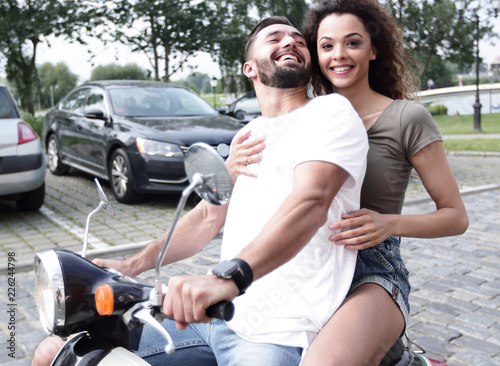 Full length side view of happy couple riding on retro motorbike