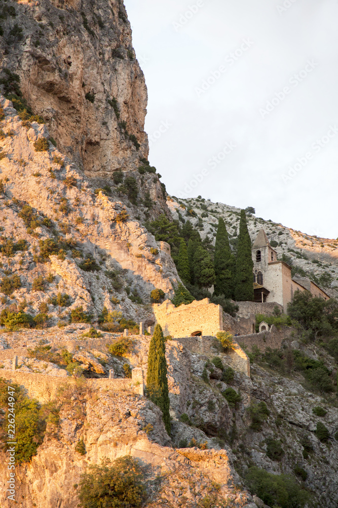 The tenth century village of Moustiers-Sainte-Marie in the Alpes-de-Haute-Provence. France. At sunset with the chapel of Notre-Dame-de-Beauvoir