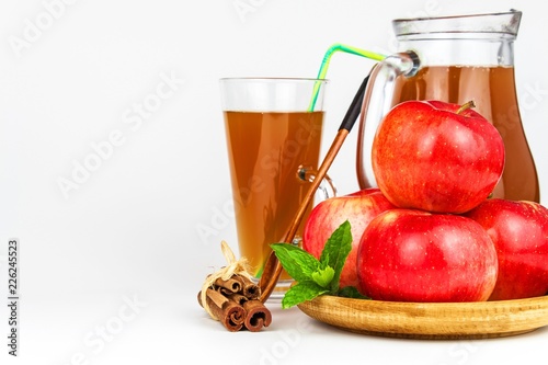 Fresh apple juice in a glass. Fruit harvest. Healthy beverage. Apples on the kitchen table. Production of juice. On a white background.