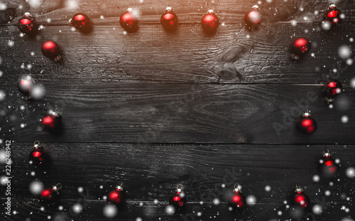 Creative christmas baubles decoration pattern with dark wooden background. Snow effect, top view