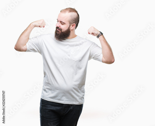 Young caucasian hipster man wearing casual t-shirt over isolated background showing arms muscles smiling proud. Fitness concept.