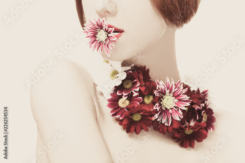 Beautiful redhead girl with flowers on white background