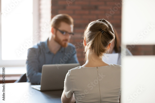 Rear view at young woman applicant seeker at job interview concept, open vacancy position candidate meeting hr making first impression, human resources, employment, hiring and recruitment concept