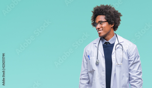Afro american doctor man over isolated background looking away to side with smile on face, natural expression. Laughing confident. photo