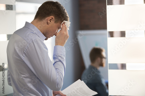 Bilde på lerret Nervous sweaty business man speaker preparing speech afraid of public speaking wiping wet forehead with handkerchief feeling stressed or worried about sweating before important office performance