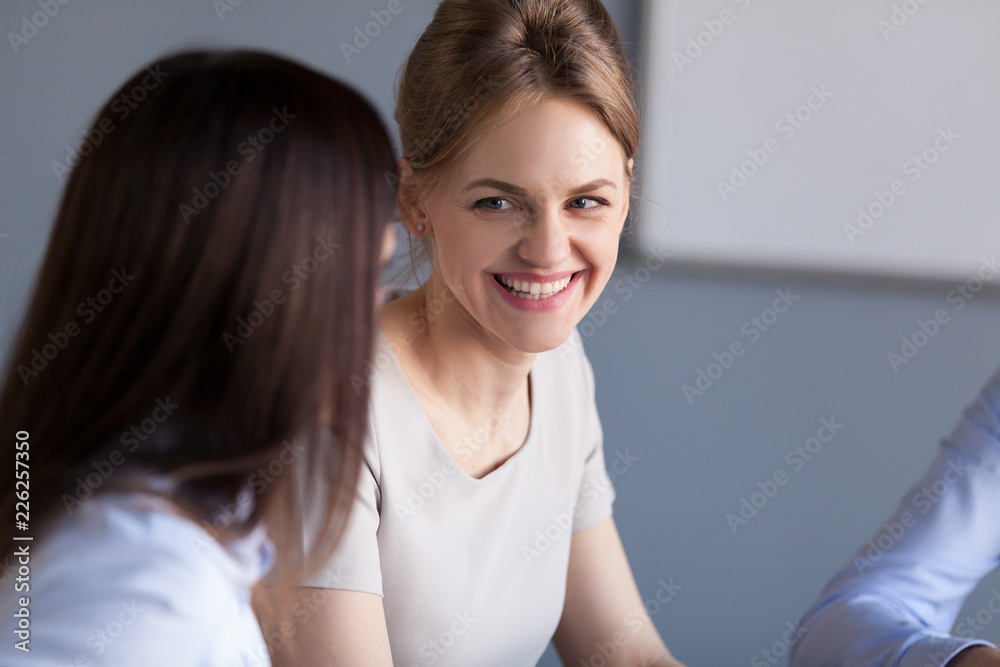 Smiling businesswoman talking to colleague at office meeting or business training, happy women chatting having conversation, good communication relations, teambuilding activity, friendship at work Smiling businesswoman talking to colleague at office meeting or business training, happy women chatting having conversation, good communication relations, teambuilding activity, friendship at work