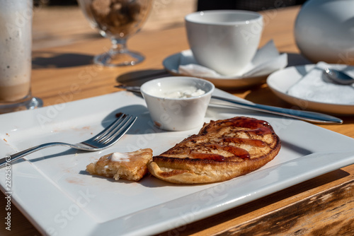 Photos Deadpan image of pancake with honey, sour cream on wooden table with fork, spoon