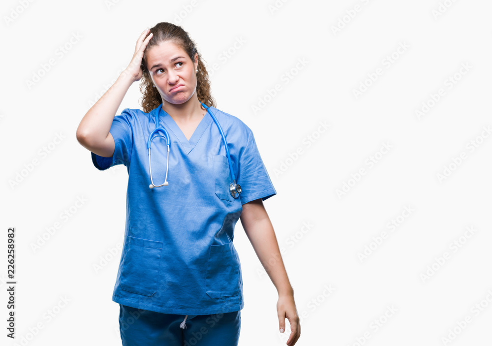 Young brunette doctor girl wearing nurse or surgeon uniform over isolated background confuse and wonder about question. Uncertain with doubt, thinking with hand on head. Pensive concept. Young brunette doctor girl wearing nurse or surgeon uniform over isolated background confuse and wonder about question. Uncertain with doubt, thinking with hand on head. Pensive concept.