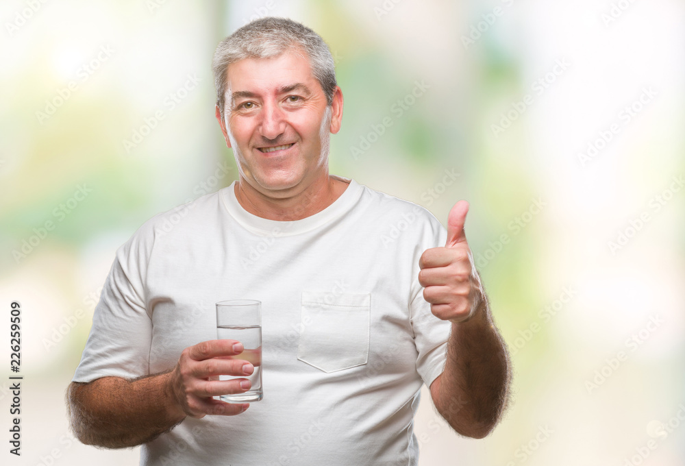 Handsome senior man drinking glass of water over isolated background happy with big smile doing ok sign, thumb up with fingers, excellent sign Handsome senior man drinking glass of water over isolated background happy with big smile doing ok sign, thumb up with fingers, excellent sign