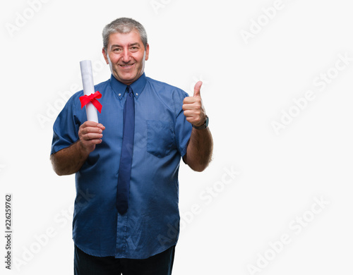 Handsome senior man holding degree over isolated background happy with big smile doing ok sign, thumb up with fingers, excellent sign