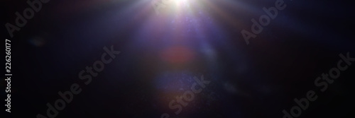 blue and purple centered and mainly off screen lens flare overlay texture with bokeh effect with black background banner
