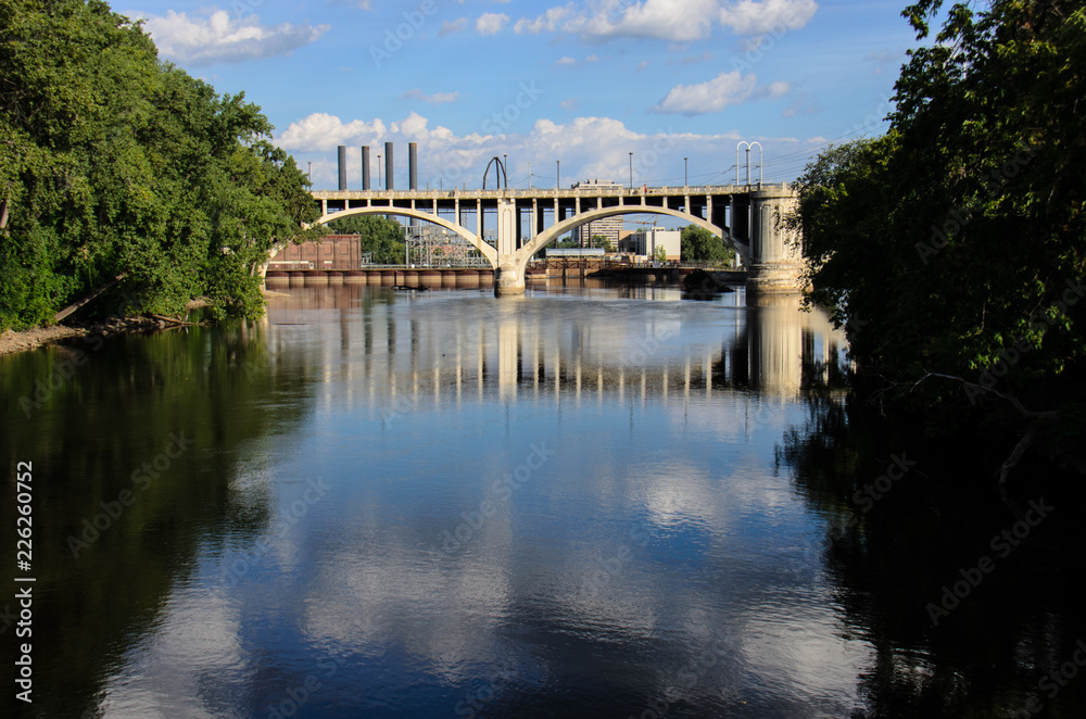  Daytime view of the I-35W Bridge in downtown Minneapolis with the Mississippi River in the foreground. Summer