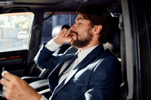 business man with a beard sits behind the wheel of a car talking on the phone © SHOTPRIME STUDIO