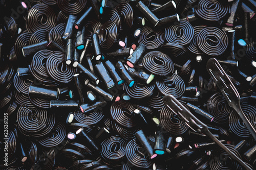 Black Or Brown Candy Spiral Background. Licorice Wheels Candies. Dark Jelly Flavored Licorice. Top View. photo