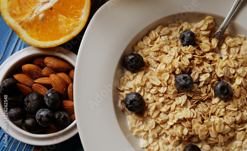 Breakfast with oatmeal and orange juice on blue wooden background