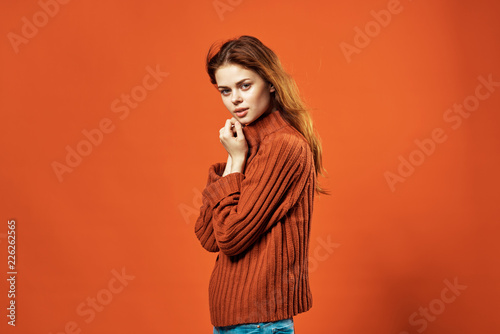 woman in a sweater on an orange background
