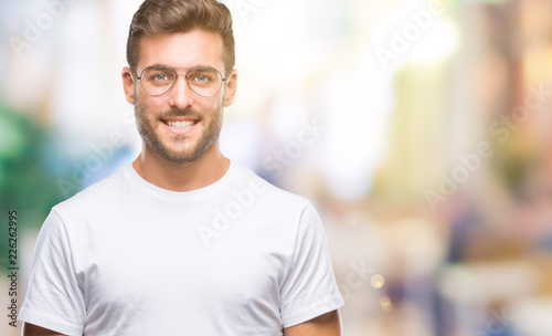 Young handsome man wearing glasses over isolated background with a happy and cool smile on face. Lucky person.