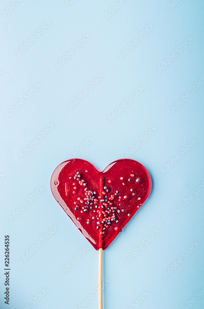Heart lollipop candy on a blue background