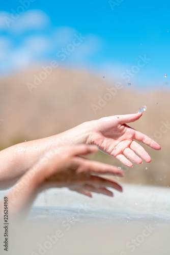 Close up of hands and drops of water on blue sky