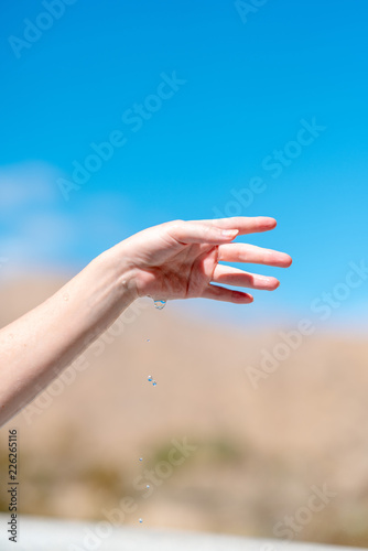Close up of hands and drops of water on blue sky