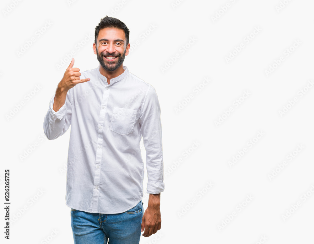 Adult hispanic man over isolated background smiling doing phone gesture with hand and fingers like talking on the telephone. Communicating concepts. Adult hispanic man over isolated background smiling doing phone gesture with hand and fingers like talking on the telephone. Communicating concepts.